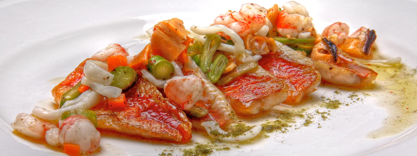 Рыбное блюдо с креветками и овощами в ресторане в Эльче